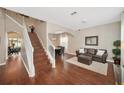 Inviting living room features hardwood floors, staircase, dining area, and a comfortable seating area at 10218 Summer Azure Dr, Riverview, FL 33578