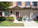 A townhome with a single-car garage, a neatly kept lawn and beautiful shrubs enhancing curb appeal at 10249 Villa Palazzo Ct, Tampa, FL 33615