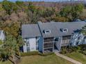 Aerial view of condo building nestled among trees, showcasing the community's serene and natural setting at 1182 Pine Ridge W Cir # B1, Tarpon Springs, FL 34688