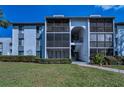 Condo building boasting screened balconies, a well-manicured lawn, and convenient pathway access at 1182 Pine Ridge W Cir # B1, Tarpon Springs, FL 34688