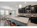 Kitchen featuring a spacious granite island with bar seating and stainless steel appliances at 11965 Cinnamon Fern Dr, Riverview, FL 33579