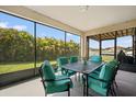 Enclosed patio featuring an outdoor table set with seating and a view of the backyard at 11965 Cinnamon Fern Dr, Riverview, FL 33579