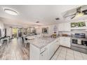 Bright kitchen open to the living area, features white cabinetry, marble countertops, and stainless steel appliances at 12924 Gulf Blvd # 110, St Petersburg, FL 33708