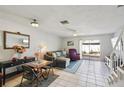 Cozy living room with tile flooring, comfortable seating, and a sliding glass door to the outdoor space at 16143 Rambling Vine E Dr, Tampa, FL 33624