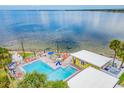 Aerial view of community pool with blue umbrellas, lounge chairs and clear ocean views at 2506 N Rocky Point Dr # 358, Tampa, FL 33607