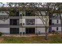 Building exterior showcasing three floors, visible screened in balcony, and mature trees at 2650 Countryside Blvd # F209, Clearwater, FL 33761
