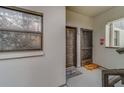 Condo hallway featuring a window with decorative film, leading to apartments with welcome mats outside at 2650 Countryside Blvd # F209, Clearwater, FL 33761