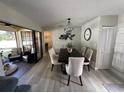 Dining room with modern light fixture, slider to patio, and neutral color palette at 3497 Birchwood Ct, Palm Harbor, FL 34684