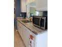 Well-lit kitchen featuring granite countertops, stainless steel appliances, a sink, and white cabinets with nickel hardware at 3710 98Th N Ave, Pinellas Park, FL 33782