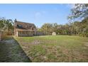 Large, grassy backyard with a partial fence, a shed, and mature trees at 404 Craft Rd, Brandon, FL 33511