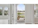 View through arched doorway of manicured landscaping, sidewalk and arched windows at 4535 Foley Grove Dr, Valrico, FL 33596