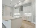 Elegant kitchen with an island featuring white cabinets and stainless steel appliances at 4535 Foley Grove Dr, Valrico, FL 33596