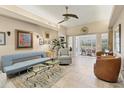 Spacious living room with a ceiling fan, tile floors, glass coffee tables, and an open view to the sunroom at 4579 Del Sol S Blvd, Sarasota, FL 34243