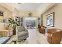 Open concept living room area with tile floors, an accent chair, plants, and an open view to the sunroom at 4579 Del Sol S Blvd, Sarasota, FL 34243
