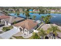 Waterfront home with a screened-in lanai, lush landscaping, and a three-car garage at 5117 Spectacular Bid Dr, Wesley Chapel, FL 33544