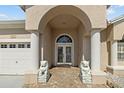 Home featuring a covered entryway with decorative lion statues and double glass doors at 5117 Spectacular Bid Dr, Wesley Chapel, FL 33544