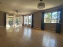 A bright living room with laminated floors, a ceiling fan, and large windows at 700 Starkey Rd # 1525, Largo, FL 33771