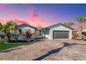 Charming single-story home featuring a driveway and beautiful tropical landscaping at 7309 Islander Ln, Hudson, FL 34667