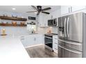 Bright kitchen with stainless steel appliances, ample counter space, and floating wood shelves for storage at 7309 Islander Ln, Hudson, FL 34667