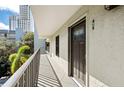 Exterior balcony showcasing neutral stucco walls, iron railings, and a view of lush greenery at 105 4Th Ne Ave # 405, St Petersburg, FL 33701