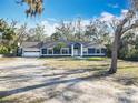 Attractive single-story home with garage, basketball hoop, mature trees and a spacious yard at 11335 Mcmullen Loop, Riverview, FL 33569