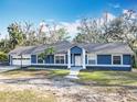 Inviting single-story home featuring an attached garage, basketball hoop, well-kept lawn, and mature trees at 11335 Mcmullen Loop, Riverview, FL 33569