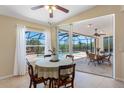 Cozy dining area with view of screened pool through sliding glass doors, offering seamless indoor/outdoor living at 182 Rotonda N Blvd, Rotonda West, FL 33947