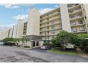 Exterior of condo building featuring a covered parking area and lush landscaping at 2800 Cove Cay Dr # 3C, Clearwater, FL 33760