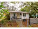 Front exterior of a cute single-story home, featuring a yellow door and small covered porch at 3425 E Powhatan Ave, Tampa, FL 33610