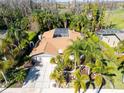 Aerial view of home with large driveway, tropical landscaping, and a screened-in pool at 375 Holly Hill Rd, Oldsmar, FL 34677