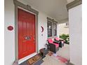 Cozy front porch featuring stylish seating, a vibrant red door, and welcoming decor for relaxing at 4136 Shrewbury Pl, Land O Lakes, FL 34638