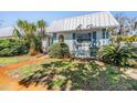 Quaint single-story home featuring lush landscaping, a verdant lawn, and a durable metal roof at 4215 Regal Pl, New Port Richey, FL 34652