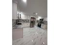 Modern kitchen boasts stainless steel appliances and attractive marble backsplash at 4731 Foothill Dr, Holiday, FL 34690