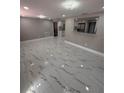 Open living room with elegant marble floors and pass-through to the kitchen at 4731 Foothill Dr, Holiday, FL 34690