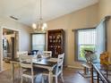 Bright dining area with wood floors, stylish lighting fixture, and views of the outdoors at 5839 Garden Lakes Dr, Bradenton, FL 34203