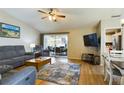 Inviting living room features wood floors, comfortable seating, and a sliding glass door to the outdoor space at 5839 Garden Lakes Dr, Bradenton, FL 34203