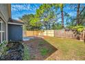 Spacious fenced backyard with a lush lawn and a well-maintained garden, perfect for outdoor relaxation and entertainment at 7459 Oxford Garden Cir, Apollo Beach, FL 33572