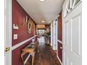 Inviting hallway with hardwood floors, decor, and an open view to the living area at 7623 Radcliffe Cir # 112A, Port Richey, FL 34668