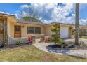 Charming single-story home featuring stone accents, manicured landscaping, and a well-maintained lawn at 834 Riverside Dr, Tarpon Springs, FL 34689