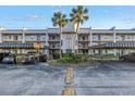 Exterior shot of condo building featuring covered parking, balconies, and neatly kept grounds at 8681 Bardmoor Blvd # 208C, Seminole, FL 33777