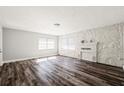 Bright living room with wood floors, white brick fireplace, and large windows providing natural light at 924 N Castle Ct, Tampa, FL 33612