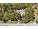 An aerial view of a charming home nestled among mature trees and lush greenery at 9377 Preston Rd, Brooksville, FL 34601