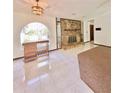 Inviting living room with stone fireplace, tile flooring, arched window, and modern lighting at 13076 Kanawha Dr, Weeki Wachee, FL 34614