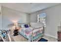 A cozy bedroom with a twin bed, window, and carpet flooring for a comfortable living space at 16868 Scuba Crest St, Wimauma, FL 33598