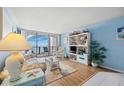 Cozy living room with nautical decor, wood floors, and sliding glass doors leading to the condo balcony at 450 S Gulfview Blvd # 605, Clearwater Beach, FL 33767