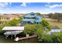 Aerial view of the blue two-story home with a private dock, boat lift, and stunning waterfront access at 541 Treviso Dr, Apollo Beach, FL 33572