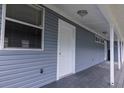 A well-maintained exterior featuring a side entrance with white pillars and blue siding at 6906 N Lynn Ave, Tampa, FL 33604