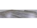 Close-up of new gray wood flooring with white baseboards in a well-lit room at 6906 N Lynn Ave, Tampa, FL 33604