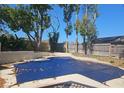 Backyard view with mature trees features a large swimming pool covered with a safety tarp at 70 Durham Ct, Palm Harbor, FL 34683