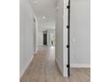 Bright hallway featuring wood-look floors leading to a glass-paned door at 7258 Kodiak Ln, Sarasota, FL 34240